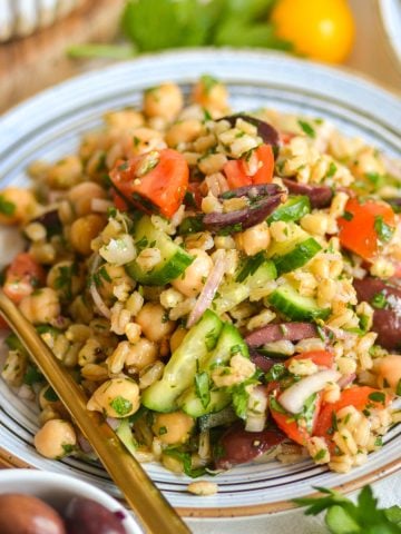 Barley salad with chickpeas, cucumbers and tomatoes on a plate.