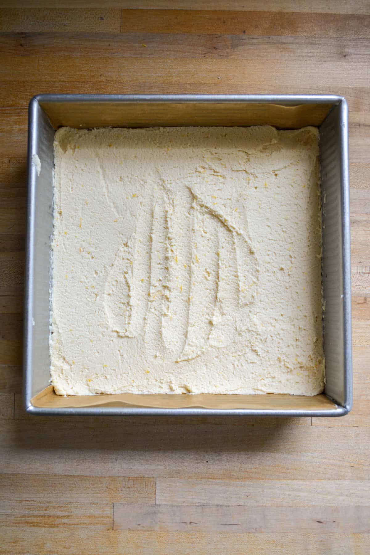 Dough pressed into a square pan.
