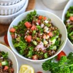 Mediterranean Black Lentil Salad in a bowl with chopped tomatoes, cucumber and parsley.