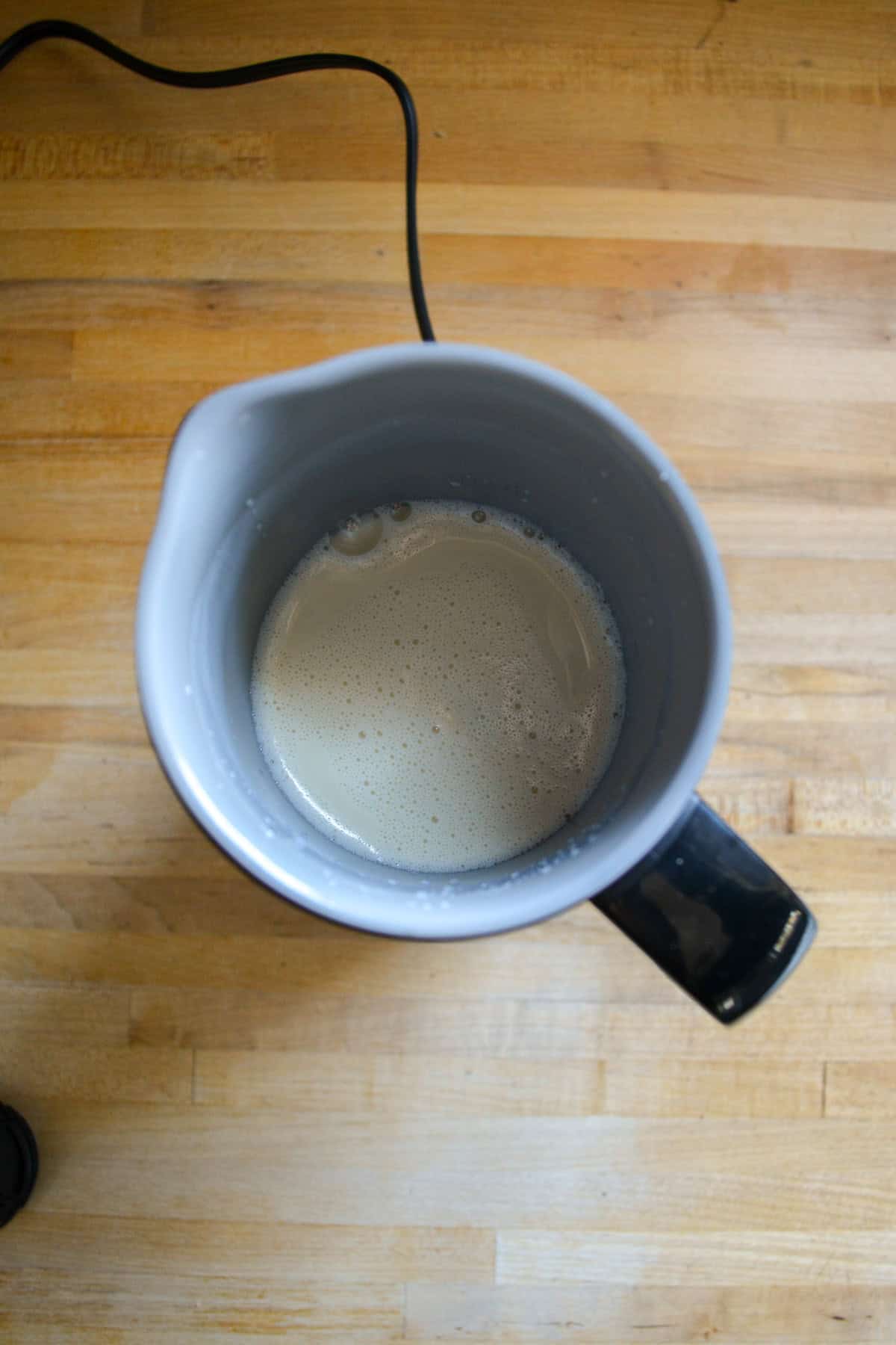 Frothing milk in a pitcher.
