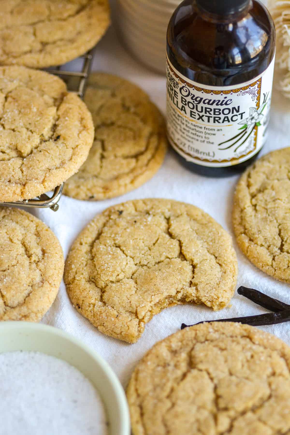 Vanilla Bean Cookie with a bite taken out of it on a linen surface.