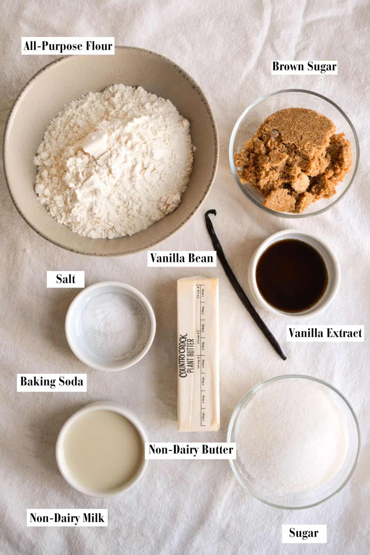 Ingredients in small bowls on a linen surface.