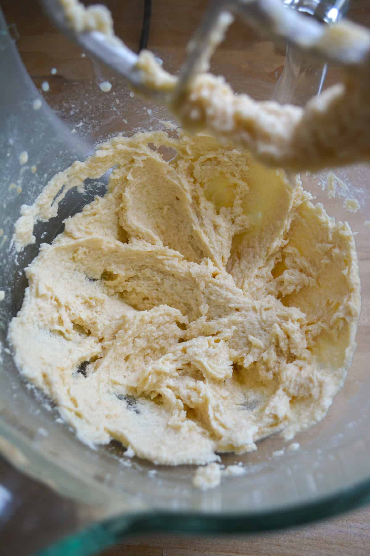 Butter and sugar creamed together in a glass bowl.