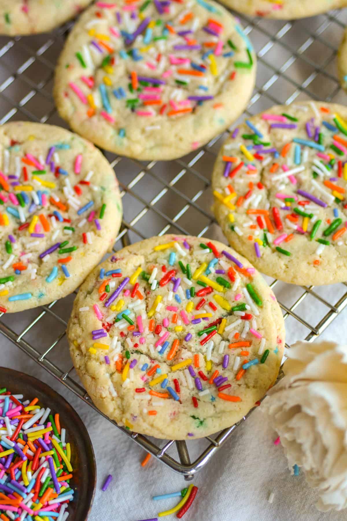 Vegan Funfetti Cookies with sprinkles on top on a wire cooling rack.