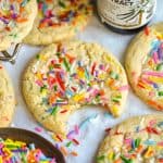 A bite taken out of a Vegan Funfetti Cookie on a linen cloth.