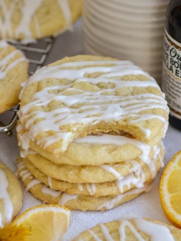 A stack of Vegan Lemon Cookies drizzled with lemon glaze.