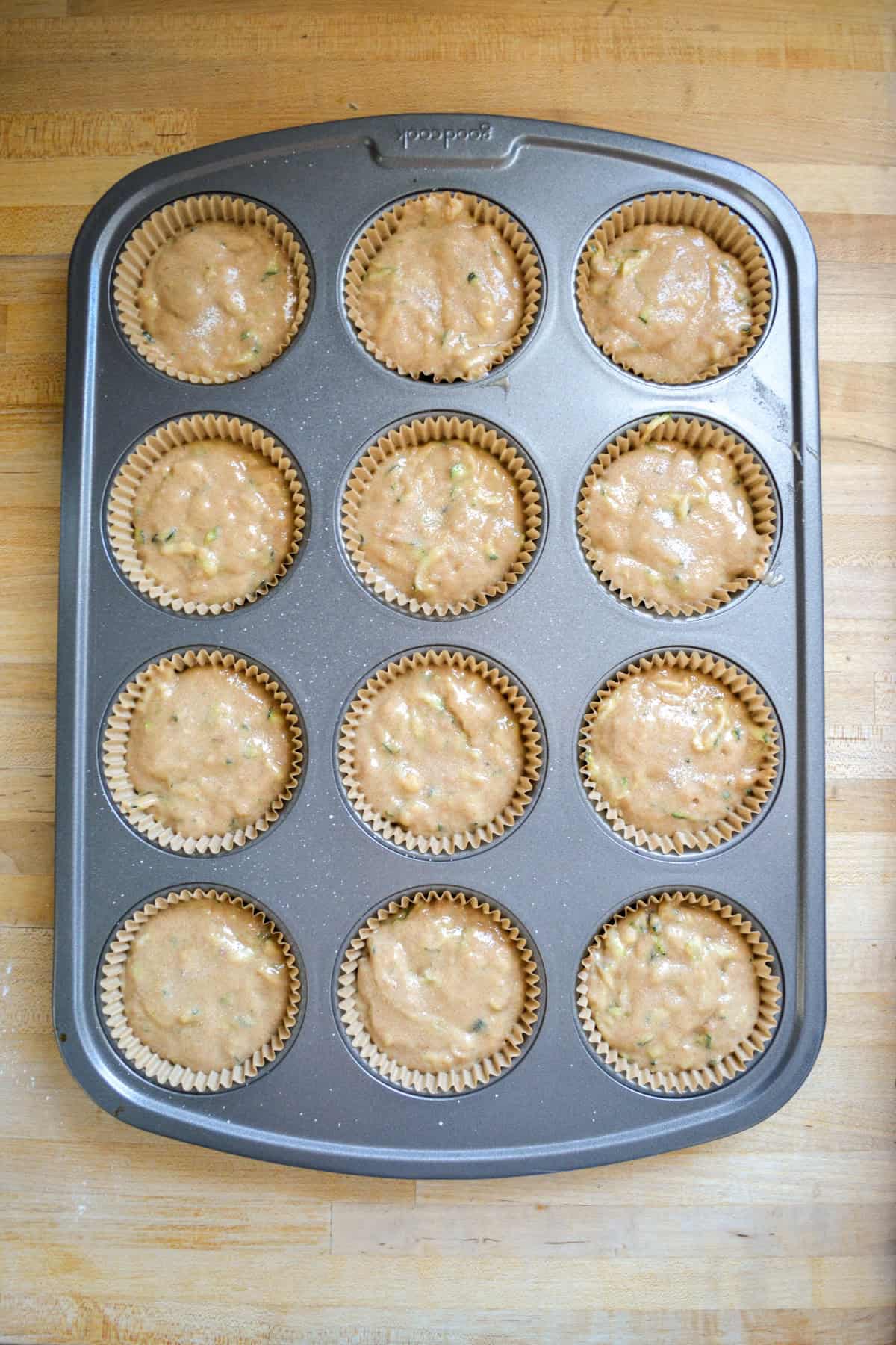 Muffin batter portioned into a muffin tin ready to bake.