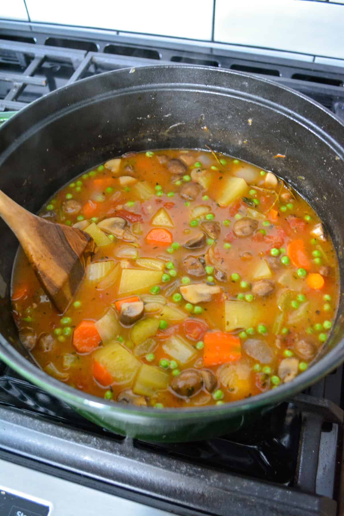 Green peas stirred into vegetable stew.