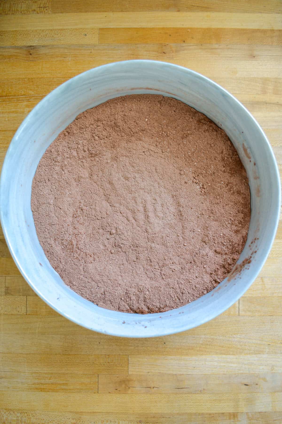 Dry ingredients for making the chocolate cake layers in a large mixing bowl.