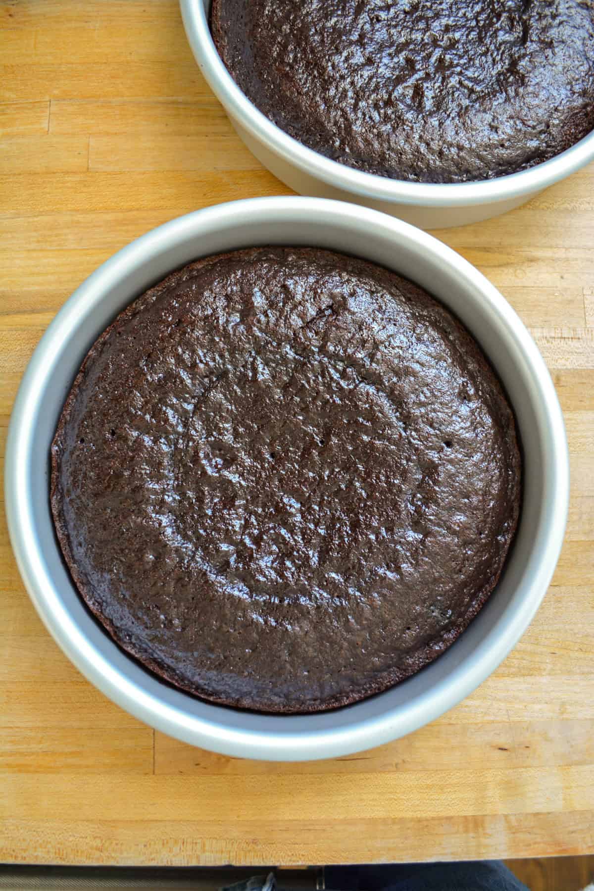 Baked chocolate cake in a round cake pan.