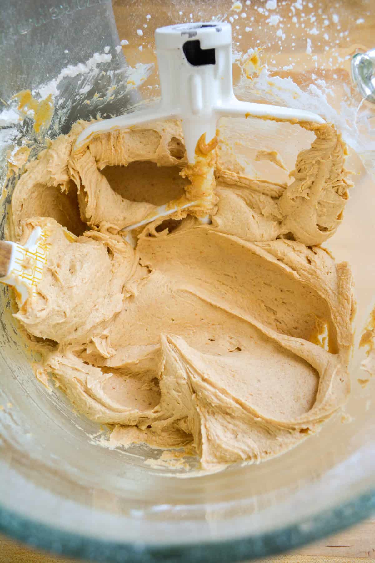 Peanut butter frosting in a glass mixing bowl.