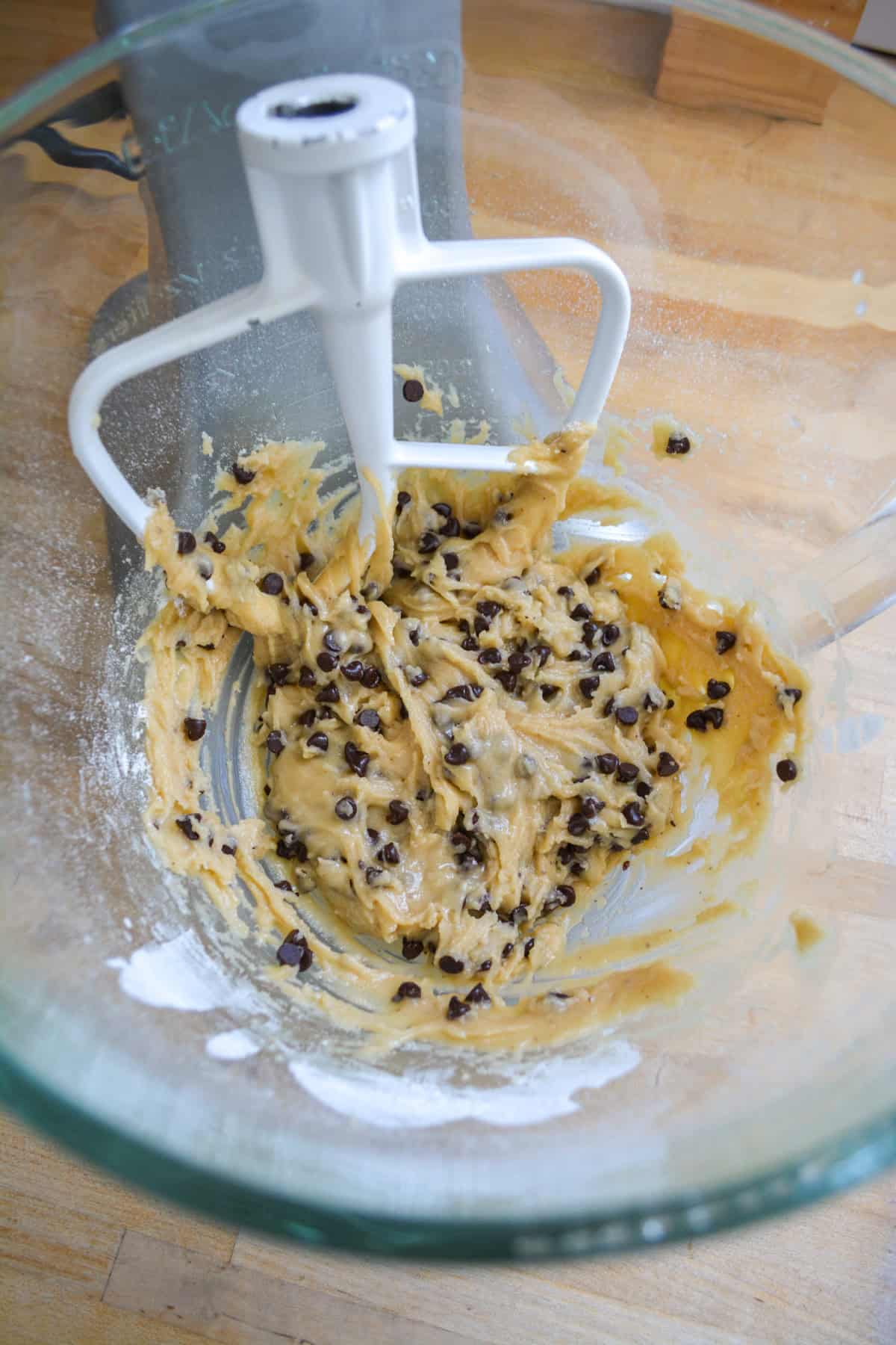 Chocolate chip cookie dough in a glass mixing bowl.