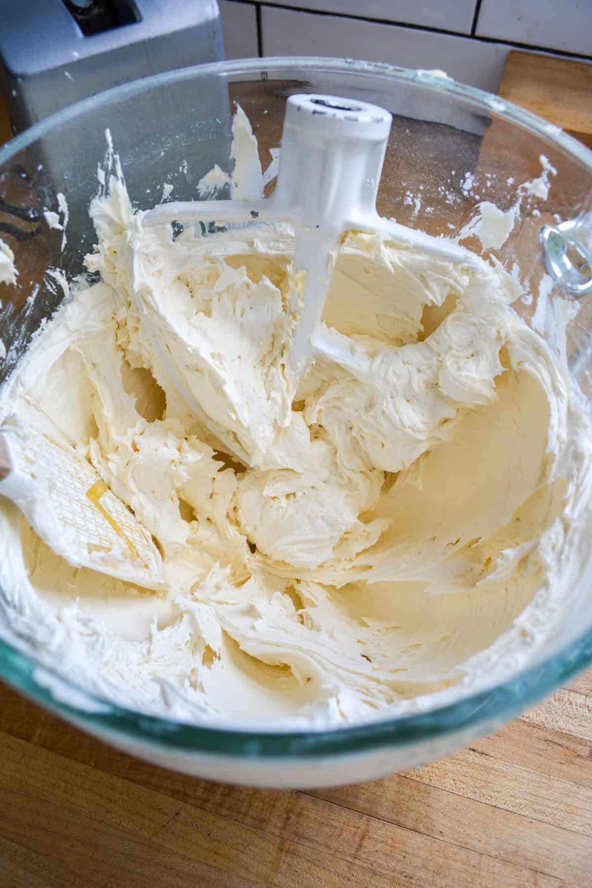 Vanilla frosting in a glass mixing bowl.