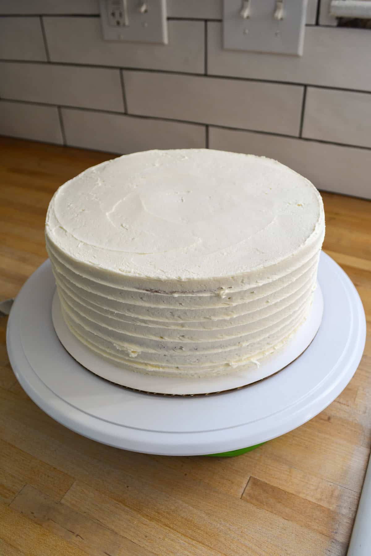A cake frosted with vanilla frosting.
