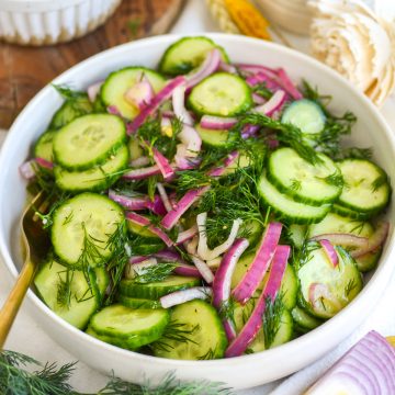 Cucumber Dill Salad with red onion in a wide, shallow bowl.