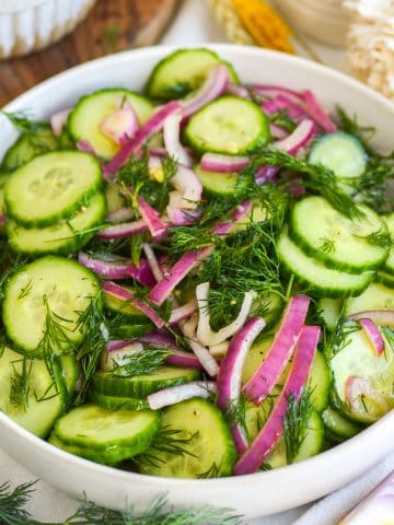 Cucumber Dill Salad with red onion in a wide, shallow bowl.