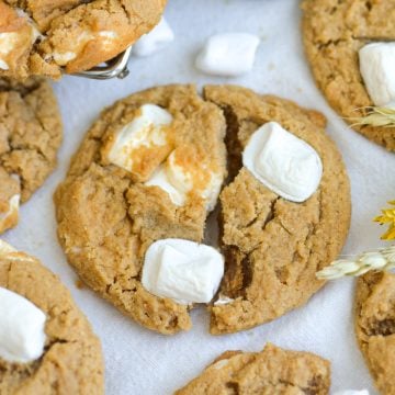 A Flutternutter Cookie broken in half on a linen surface.