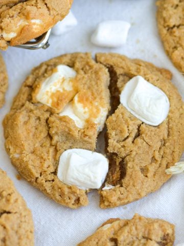 A Flutternutter Cookie broken in half on a linen surface.