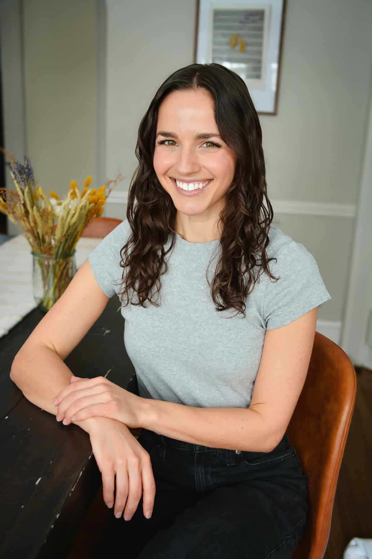 Headshot of a woman with brown curly hair.