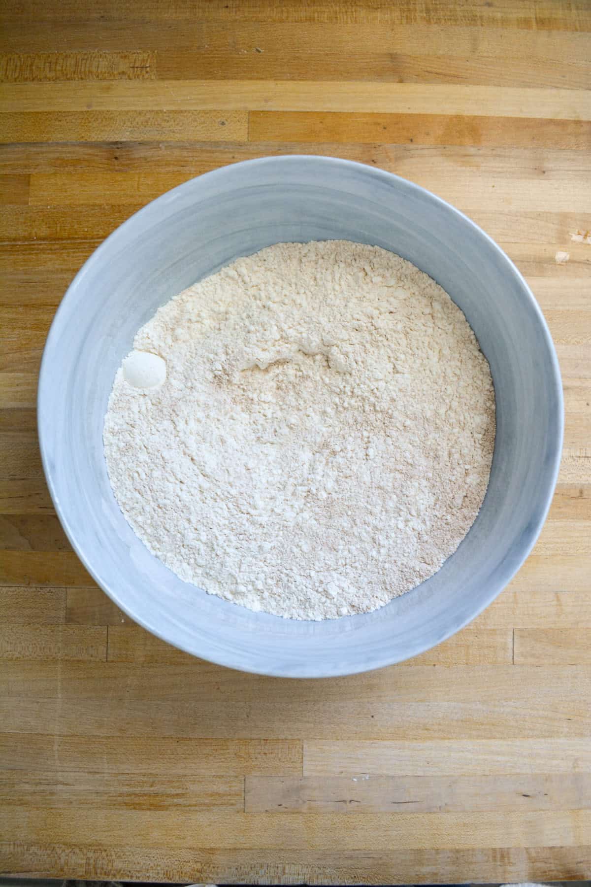 Dry ingredients in a large bowl on a wooden surface.