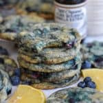 A stack of Vegan Blueberry Lemon Cookies with a bite taken out of the top cookie.