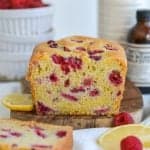 Vegan Raspberry Lemon Loaf Cake on a wooden cutting board.