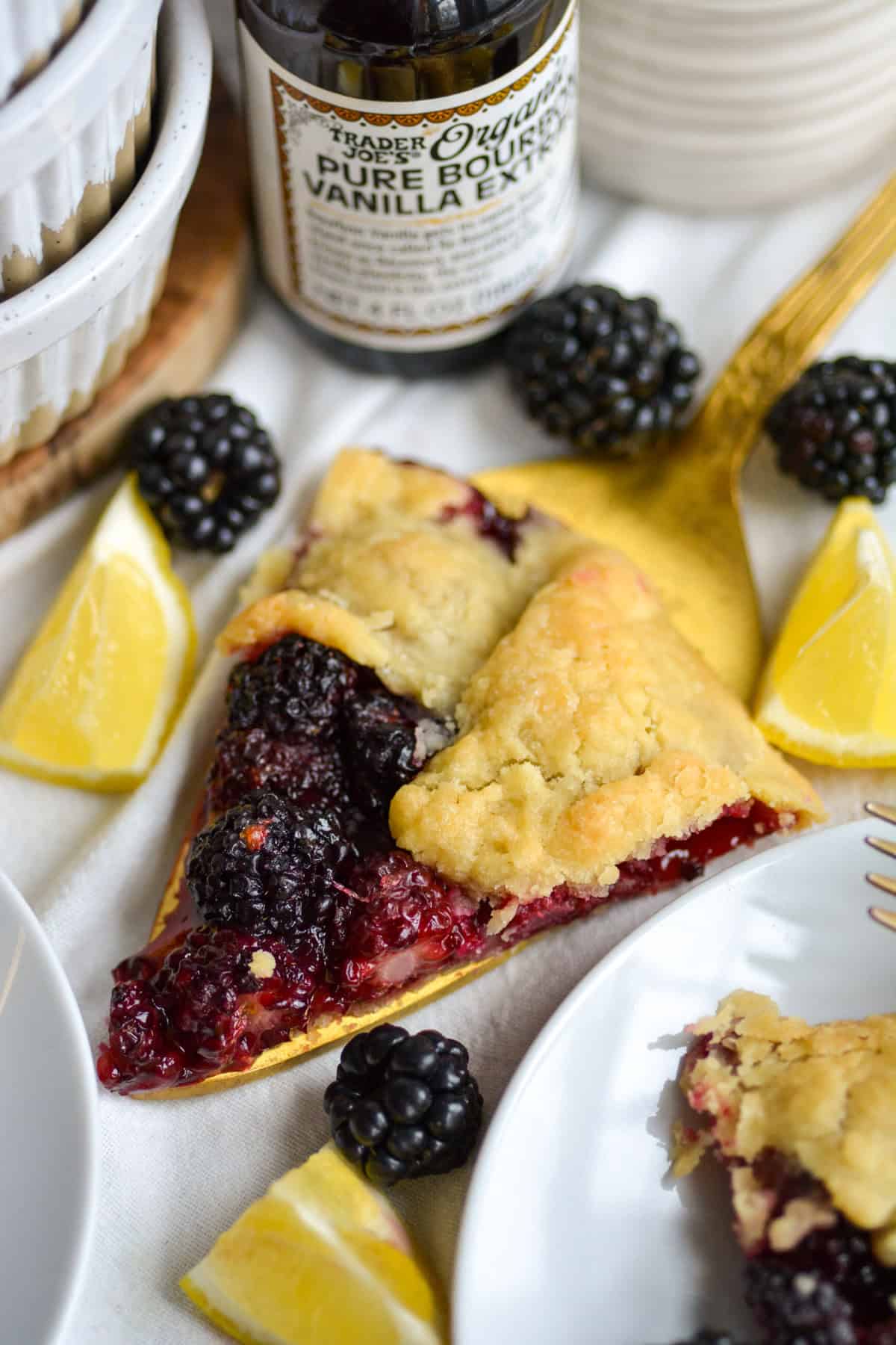 A slice of Blackberry Galette on a gold pie server.