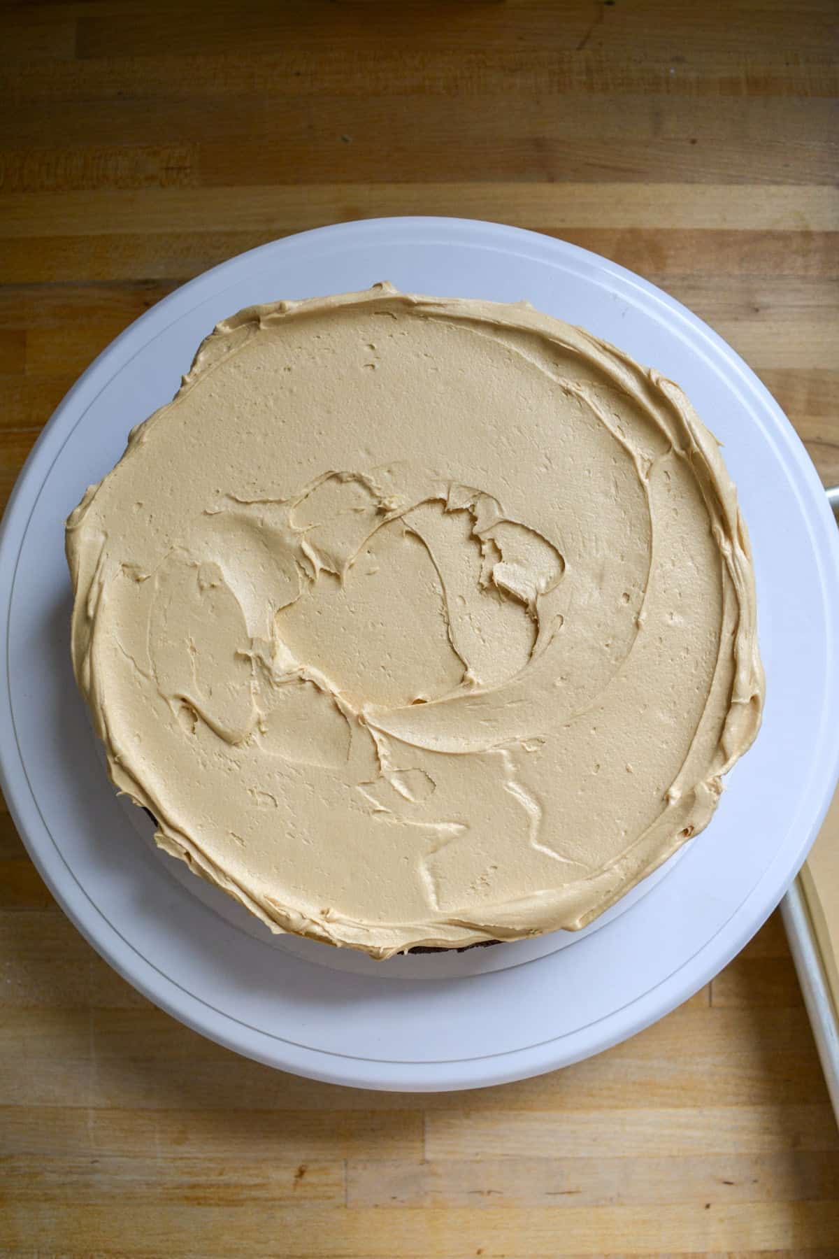 Espresso frosting spread onto a chocolate cake layer.