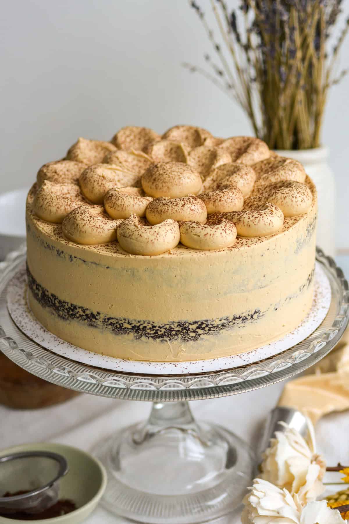 Chocolate Espresso Cake dusted with cocoa powder on a glass cake stand.