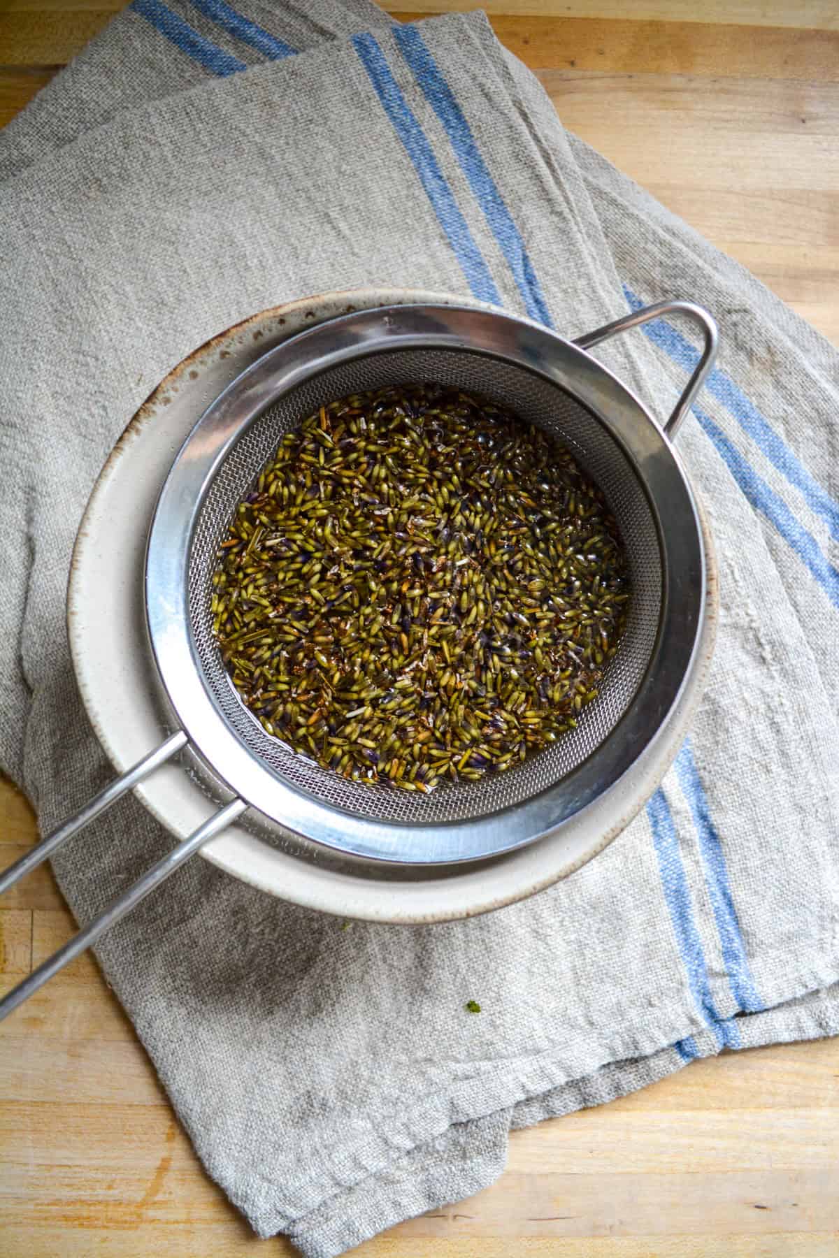 Straining lavender flowers out of syrup.