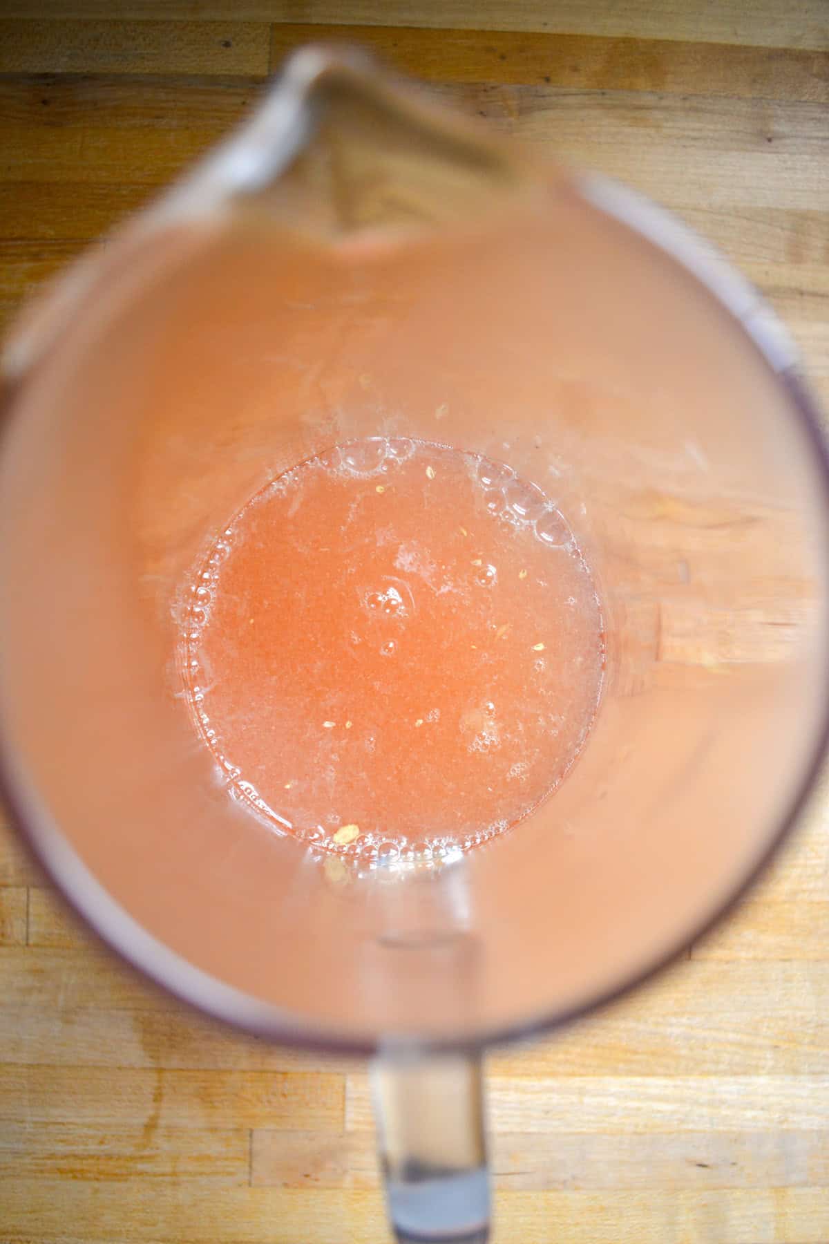 Lavender syrup and lemon juice in the bottom of a large pitcher.