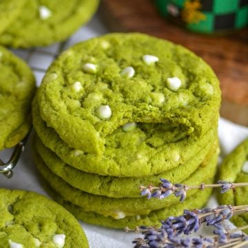 A stack of Vegan Matcha White Chocolate Cookies with a bite taken out of the top cookie.