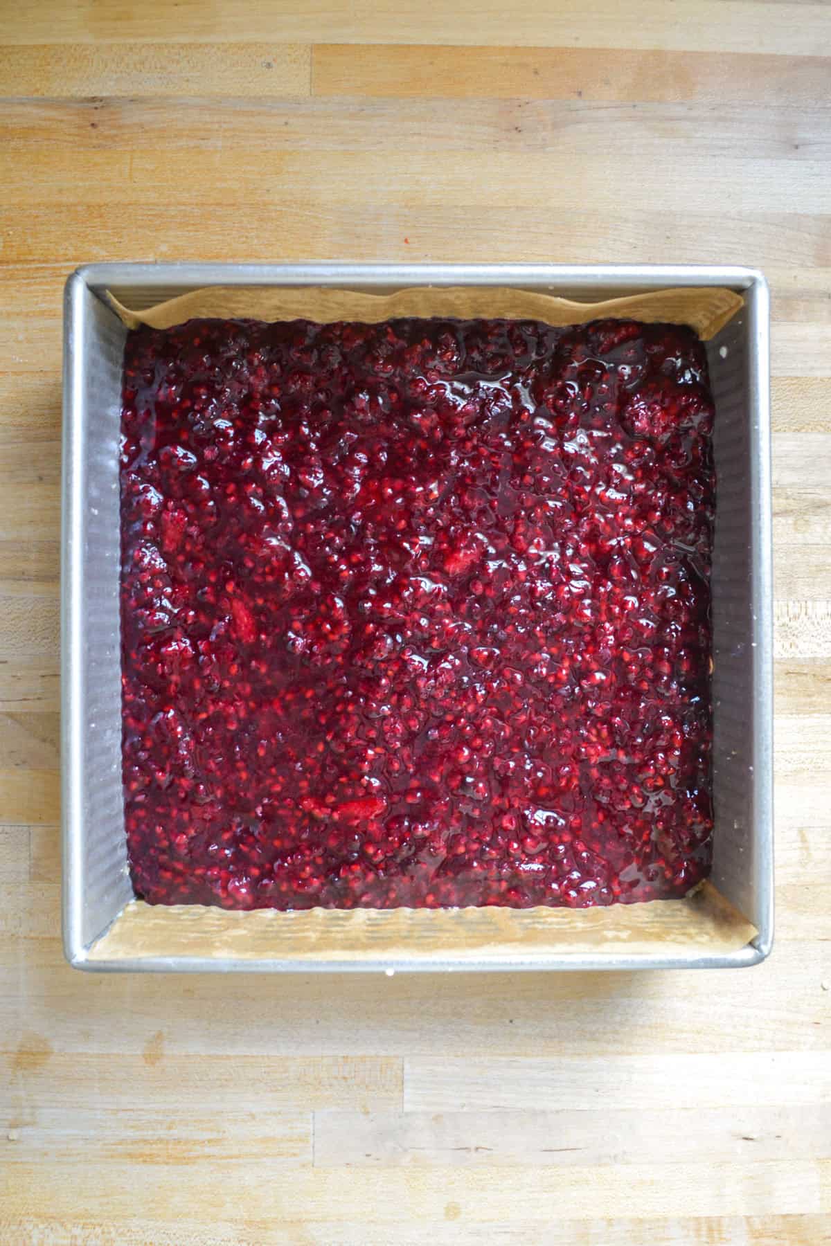 Blackberry filling poured into a square baking pan.