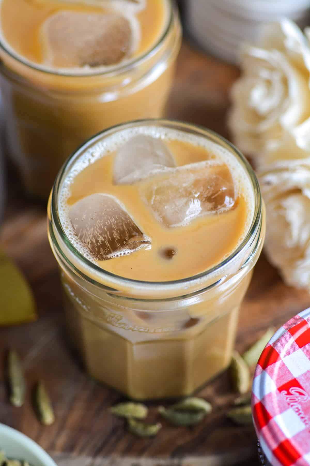 Cardamom Latte in a glass on a wooden board.