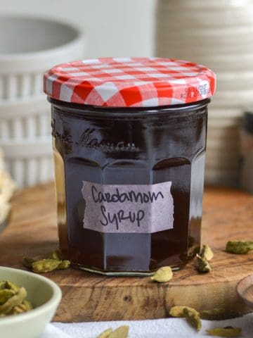 Cardamom syrup in a jar with a label on it.
