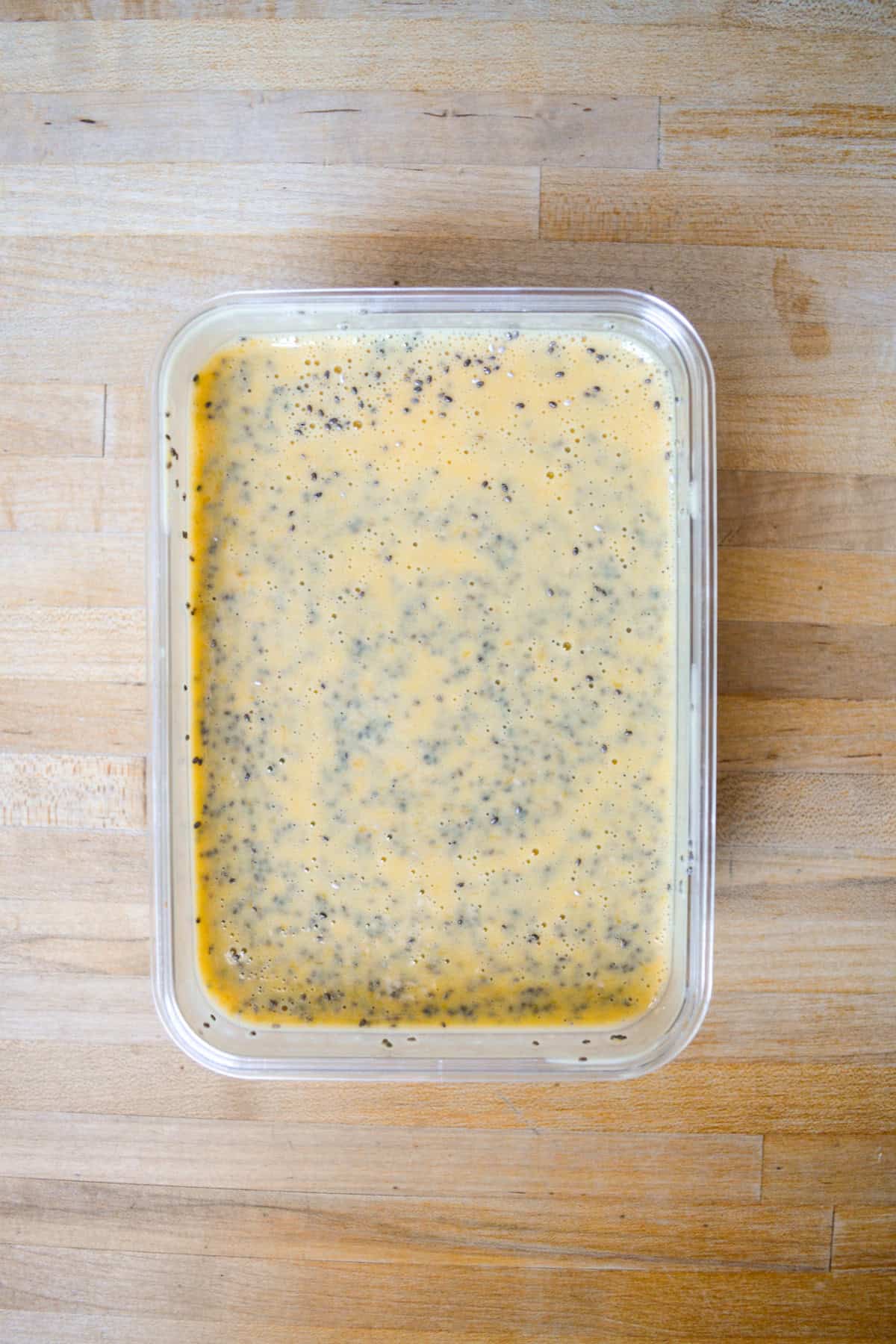 Chia seeds and the mango mixture stirred together in a container.