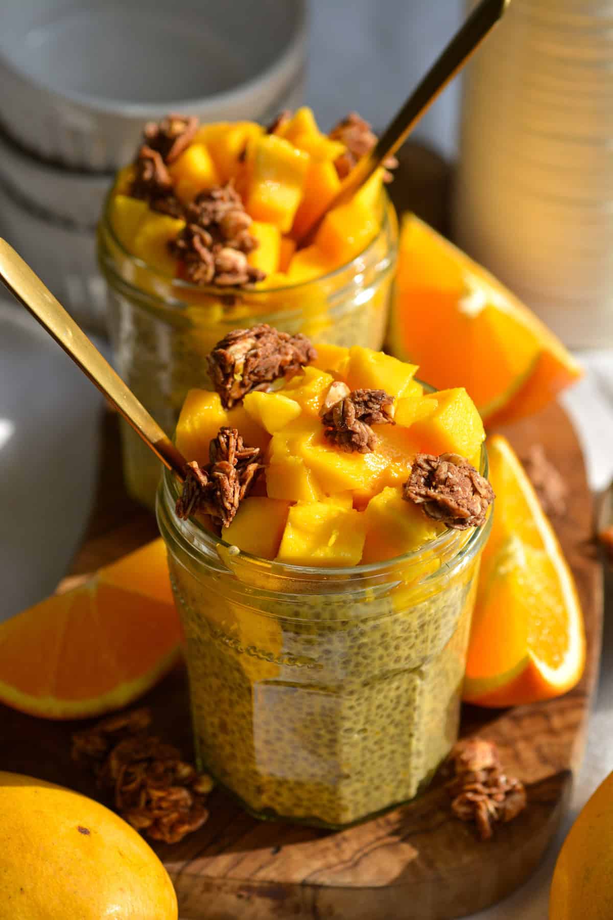 Mango Chia Seed Pudding in a glass jar topped with mango chunks and granola.