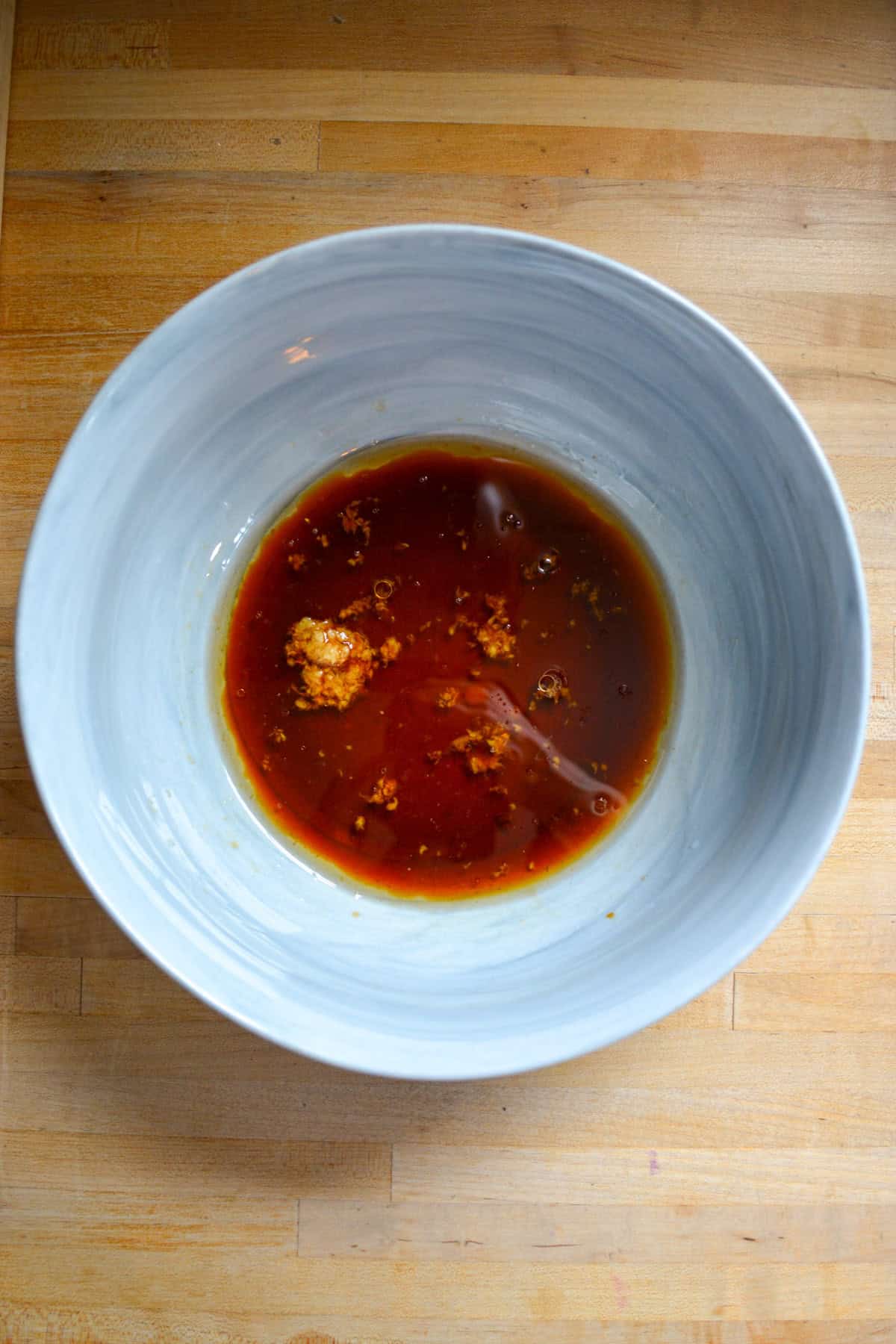 Sesame-soy dressing in the bottom of a large mixing bowl.