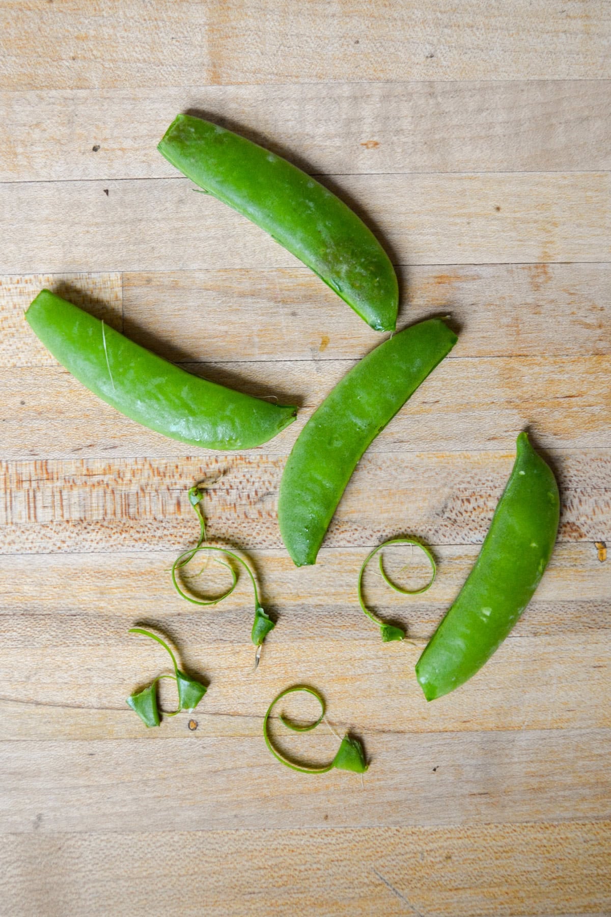 Peas with their stem ends snapped off.
