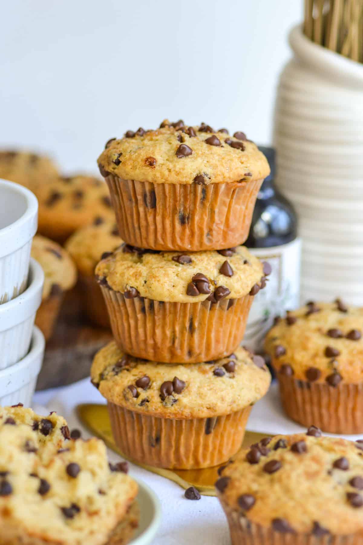 Three Vegan Chocolate Chip Muffins stacked on top of each other.
