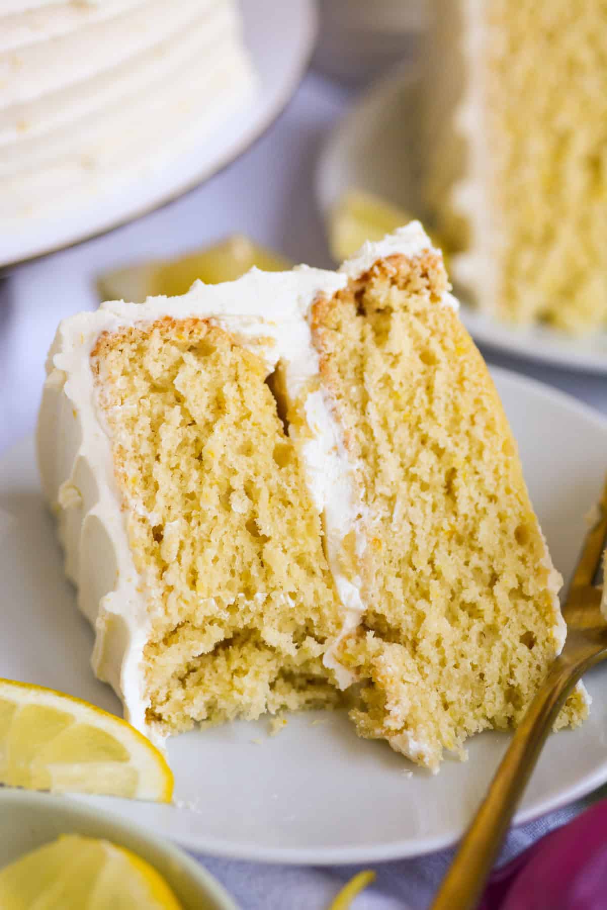A slice of vegan layer cake on a plate with a bite taken out of it.