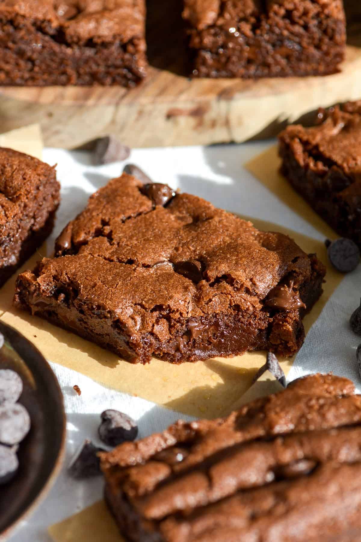 A Chocolate Chocolate Chip Cookie Bar with a bite taken out of it on a linen surface.