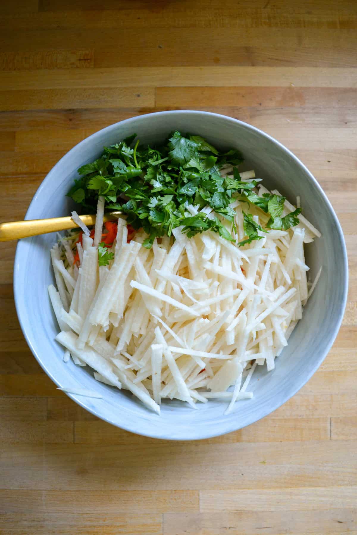 Jicama Slaw ingredients in a large bowl ready to be mixed together.