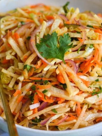 Jicama Slaw in a bowl topped with cilantro.