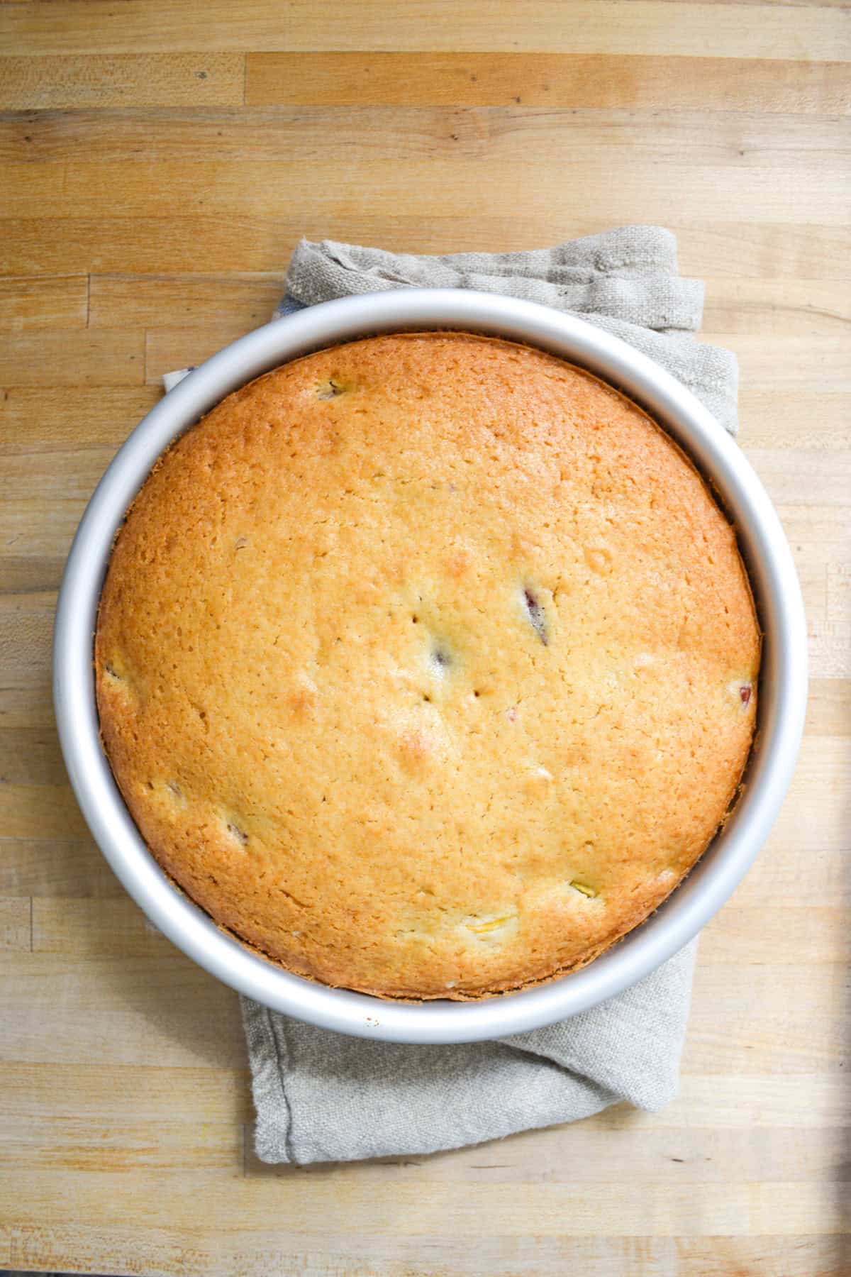 Baked peach cake in a round cake pan.