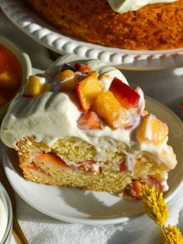 A slice of peaches and cream cake on a small plate.