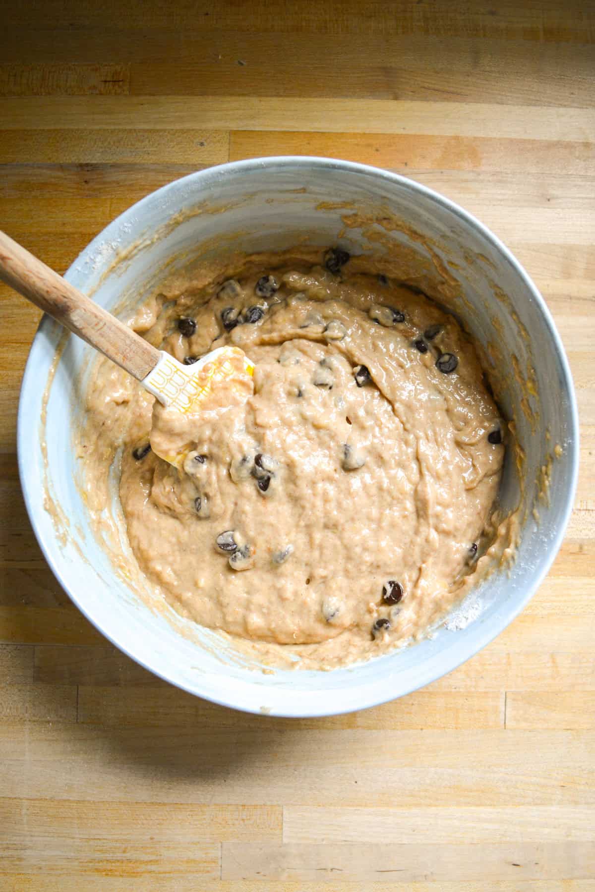 Vegan Banana Muffin batter with chocolate chips in a large mixing bowl.