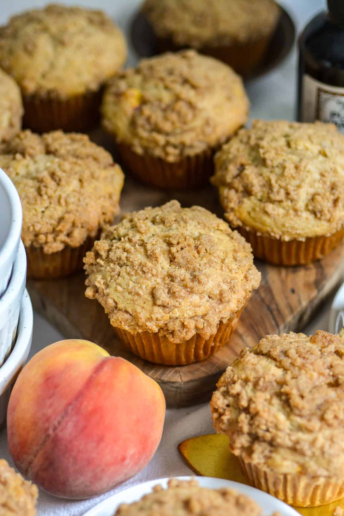 Vegan Peach Coffee Cake Muffins on a wooden board.