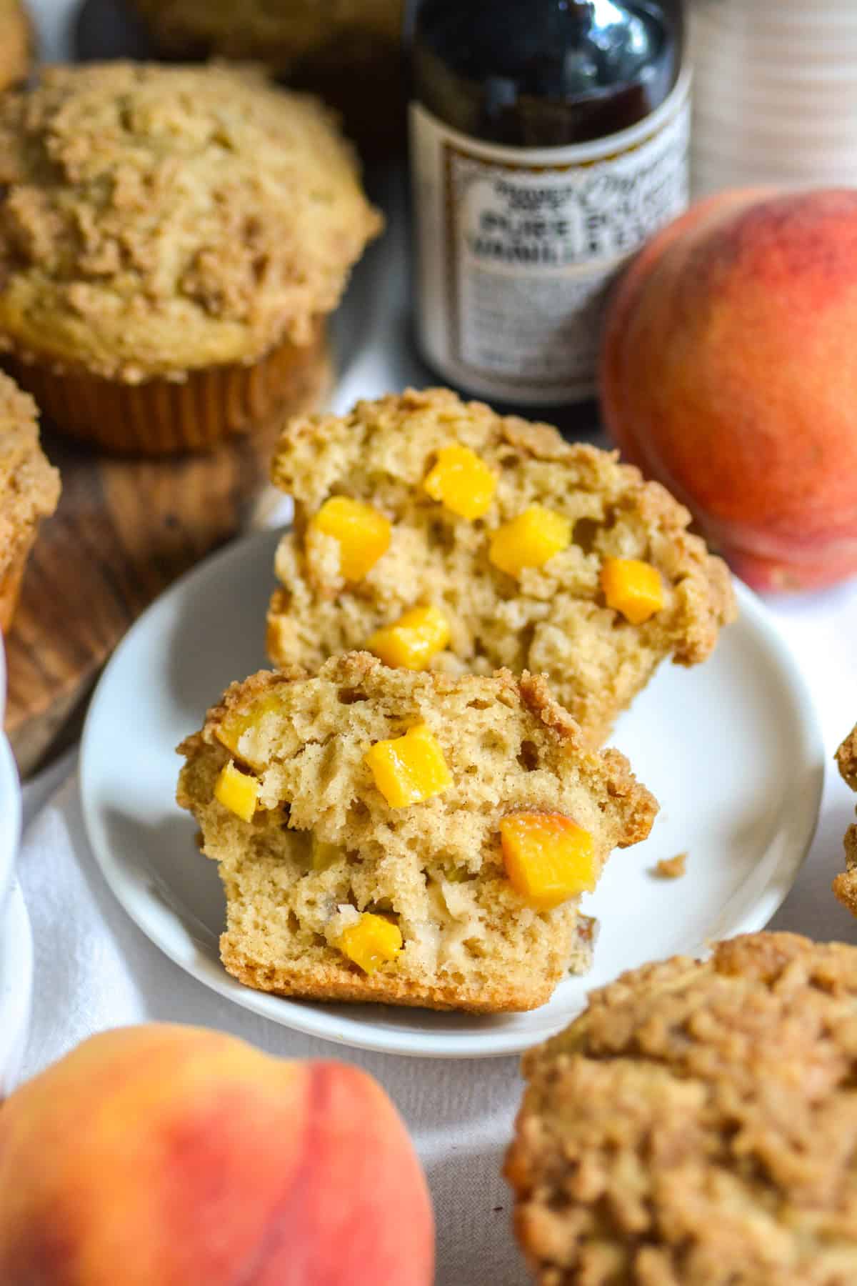 A Vegan Peach Coffee Cake Muffin cut in half to show the fluffy interior.