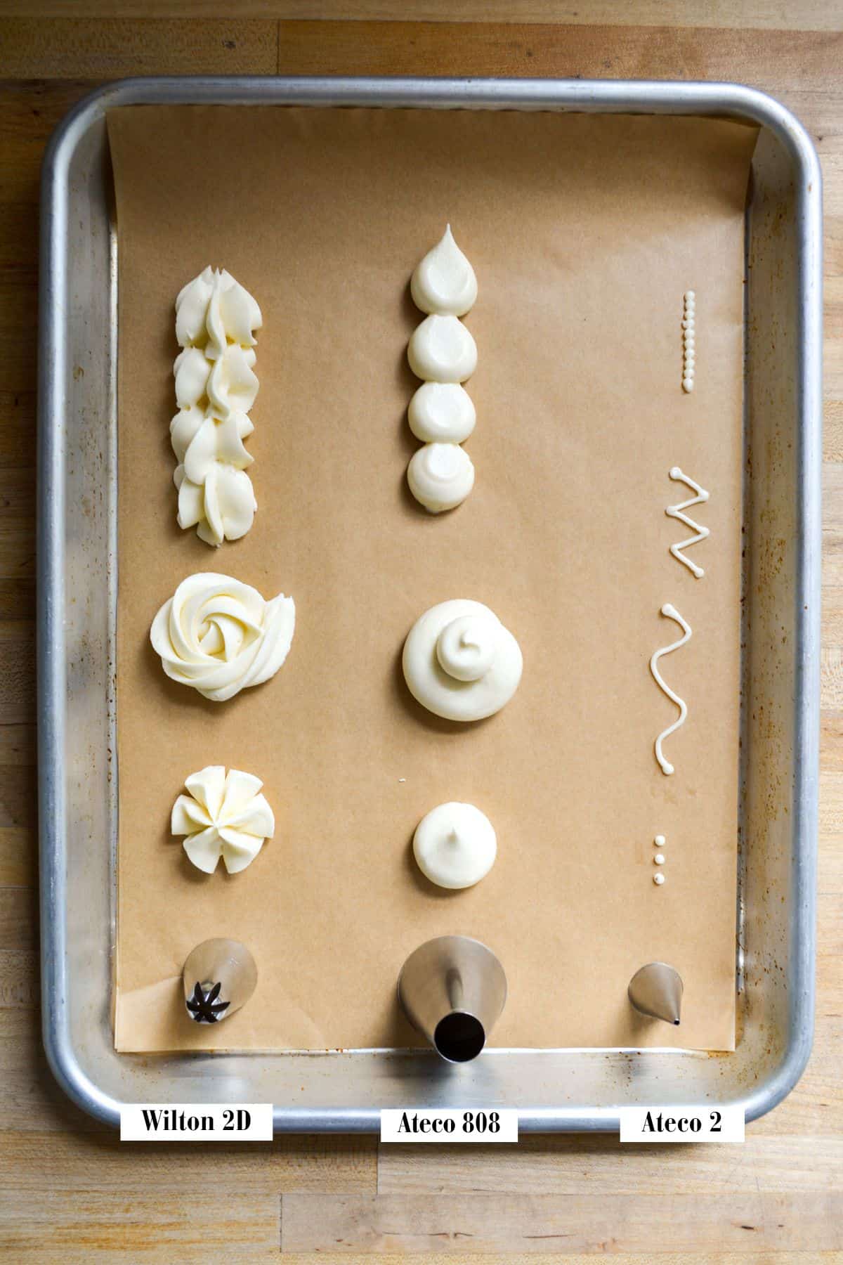 Piping tips with frosting piped onto parchment.